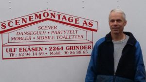 Bildet viser Ulf Ekåsen foran logoen til Scenemontage